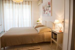 a bedroom with a bed and a table with a lamp at Résidence les Ibis Location entre mer et montagne in Toulon