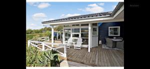 a porch of a house with a deck with chairs at Family House Near Beach And Coastal Nature in Karrebæksminde