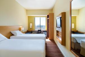 a hotel room with two beds and a television at ibis Deira Creekside Dubai in Dubai