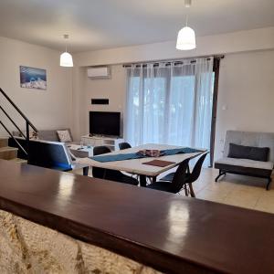 a living room with a table and a couch at Holiday Home Kriopigi in Kriopigi +5 photos