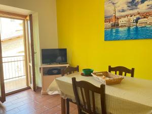 a dining room with a table and a television at Orchidea Retreat - View of Mountains & Vines in San Demetrio neʼ Vestini