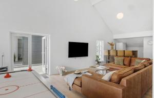 a living room with a couch and a flat screen tv at Lovely Home In Løkken With Sauna in Løkken
