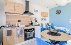 a small kitchen with a table and blue chairs at Jolie Maison Proche Plage in Le Crotoy