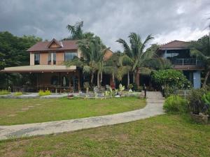 a house with palm trees in front of it at The Leaf Pool Villa Resort in Muak Lek District