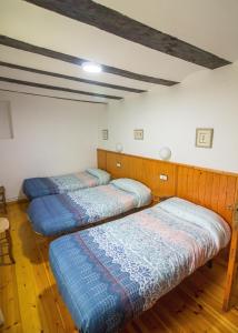 three beds in a room with wooden floors at Apartmento A in Benasque
