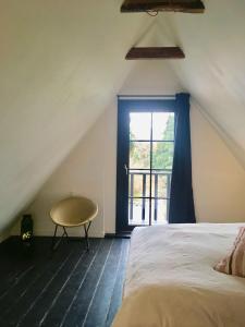 a attic bedroom with a bed and a window at Old Guardhouse On West Møn in Askeby