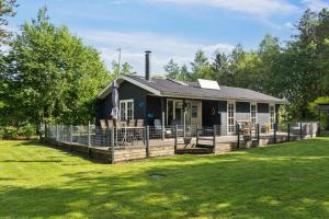 a house with a fence in front of a yard at Dog-Friendly Holiday Oasis With Peace And Nature in Hadsund