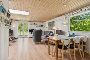 a dining room and living room with a table and chairs at Dog-Friendly Holiday Oasis With Peace And Nature in Hadsund +20 photos