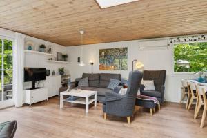 a living room with a couch and a table at Dog-Friendly Holiday Oasis With Peace And Nature in Hadsund
