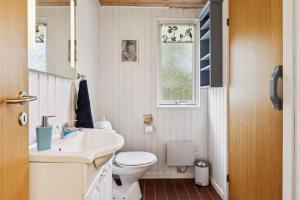 a bathroom with a sink and a toilet and a window at Dog-Friendly Holiday Oasis With Peace And Nature in Hadsund