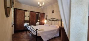 a bedroom with a bed with white sheets and a chandelier at La Casa di Edo 