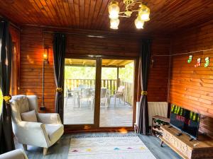 a living room with a sliding glass door with a television at Kızıl Kum Villa 