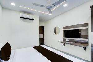 a bedroom with a bed and a flat screen tv at Hotel O Vijaya Grand in Pedda Ambarpet