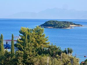 an island in the ocean with a house and trees at Dine Hotel in Ksamil
