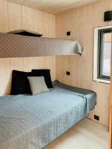 a bedroom with a bed in a wooden wall at Modern Cabin With Midnight Sun In Skjomen in Narvik