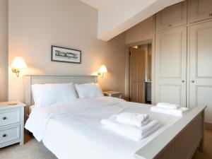 Un dormitorio con una gran cama blanca con toallas. en Aloft, en Salcombe 8 fotos más