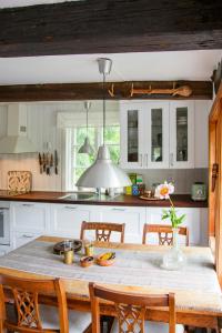 a kitchen with a wooden table with chairs and a tableablish at The Hallandsåsen Lighthouse, A Natural Retreat in Munka-Ljungby