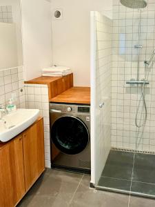 a bathroom with a washing machine and a sink at Historic Laundry House By Gentofte Lake in Gentofte
