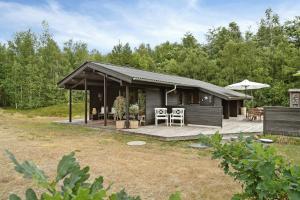 a house with a deck and a patio at Simple Life In Traditional Home By Lyngså Beach in Sæby