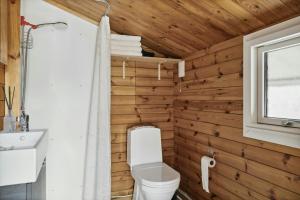 a bathroom with wooden walls and a toilet and a window at Simple Life In Traditional Home By Lyngså Beach in Sæby +20 photos