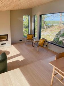 a living room with furniture and a large window at Modern Beach House At Røssesund Tjøme in Tjøme