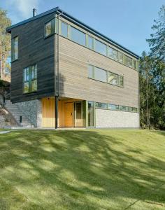 a house with a large lawn in front of it at Modern Beach House At Røssesund Tjøme in Tjøme +26 photos