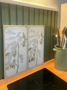 two stenciled panels of flowers on a wall at Retro Cottage With Fjord View in Storvorde