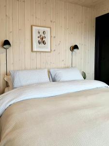 Un dormitorio con una cama grande con dos lámparas. en New Cabin With Ocean Views In Vesterålen, en Straumsjøen