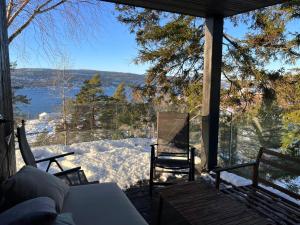 a screened in porch with a view of the water at Traditional Cabin In Modern Drøbak in Drøbak