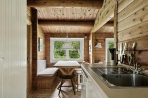 Una cocina con fregadero y ventana en una cabaña de troncos. en Log Cabin Near Vesterstrand On Anholt, en Anholt 64 fotos más