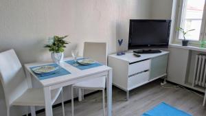 a living room with a white table and a tv at Kasarminkadun Basic Cozy 19,5 m2 in Vaasa