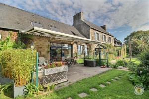 a house with a patio and a yard at La grange in Penvénan
