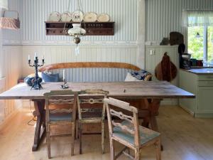 a kitchen with a wooden table and chairs at Cultural Cottage By Lake Fryken In Värmland in Östra Ämtervik