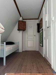 a attic room with a bed and a door at Cultural Cottage By Lake Fryken In Värmland in Östra Ämtervik