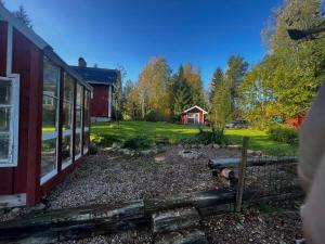 a view of a yard with a red barn at Cultural Cottage By Lake Fryken In Värmland in Östra Ämtervik +16 photos