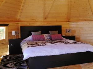 a bedroom with a large bed in a wooden room at Nomad Planet in Fiães do Rio