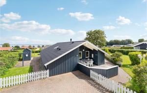 a black house with a black roof and a white fence at Cassiopeia in Sjølund +15 photos