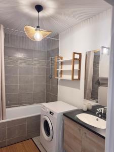 ブゾンにあるAppartement moderne proche La Défenseの洗濯機と洗面台を備えたバスルーム