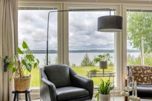 Una sala de estar con una silla y una ventana grande. en Villa Vilkama, en Laukaa