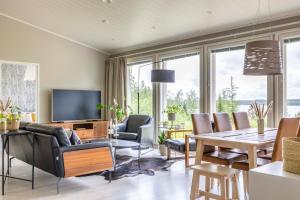 Una sala de estar con una mesa y sillas y un televisor. en Villa Vilkama, en Laukaa