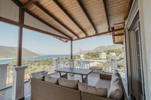 a patio with a table and couch on a balcony at Villazart in Porto Germeno