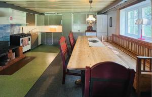 a large kitchen with a wooden table and chairs at 2 Bedroom Awesome Home In Östmark in Östmark