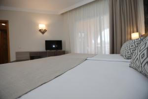 a bedroom with a large bed and a television at Hotel Puerto Palace in Puerto de la Cruz