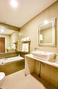 a bathroom with a sink and a toilet and a mirror at Palm Continental Hotel in Johannesburg