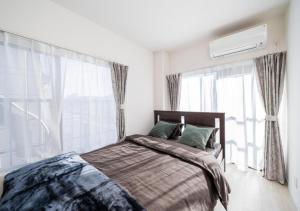 Un dormitorio con una cama y una ventana grande. en Kasai Light Luxury Hotel 301, en Tokio