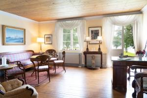 a living room with a table and chairs and windows at Saxå Bruk in Filipstad