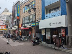 a man walking down a street in a city at Matsuri House 20min to Ueno in Tokyo