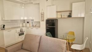 a kitchen with a couch and a table and a black refrigerator at Apartamento IBY in Castro-Urdiales