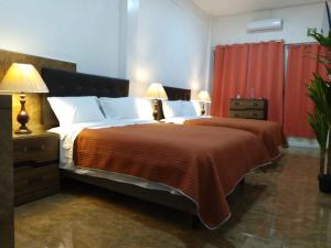 a bedroom with a large bed with a orange blanket at Gran Tonantzin in San Martín de las Pirámides