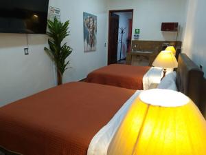 a hotel room with two beds and a television at Gran Tonantzin in San Martín de las Pirámides